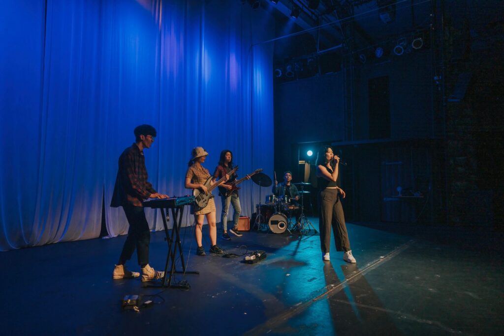 Young Asian chinese lead singer and live band Multiracial group performance on stage